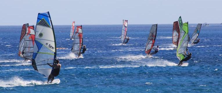 group of wind surfers moving across ocean surface